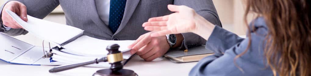 two people negotiating at a table with a gavel between them