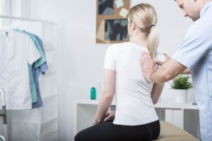 chiropractor adjusting a patient's spine in their office