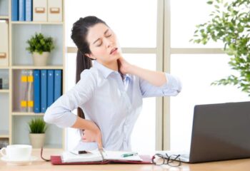 business woman with back pain and neck pain in office