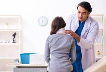 Doctor examining patient suffering from whiplash's neck and brace after a car accident