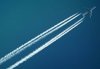 and airplane in the air with contrails