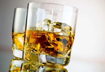 close up view of a glass of whiskey and ice