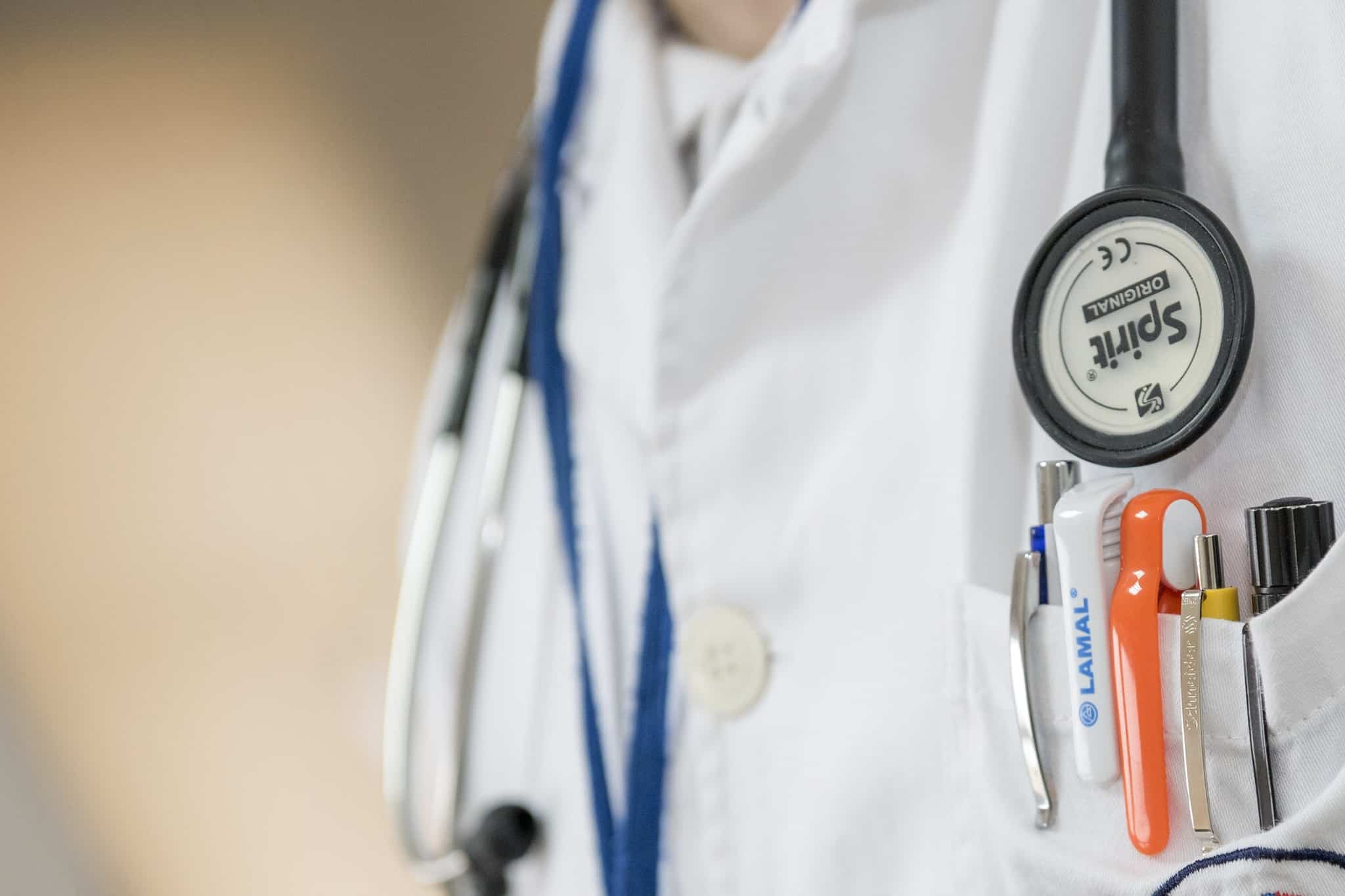 close up on a doctor's lab coat pocket and stethoscope