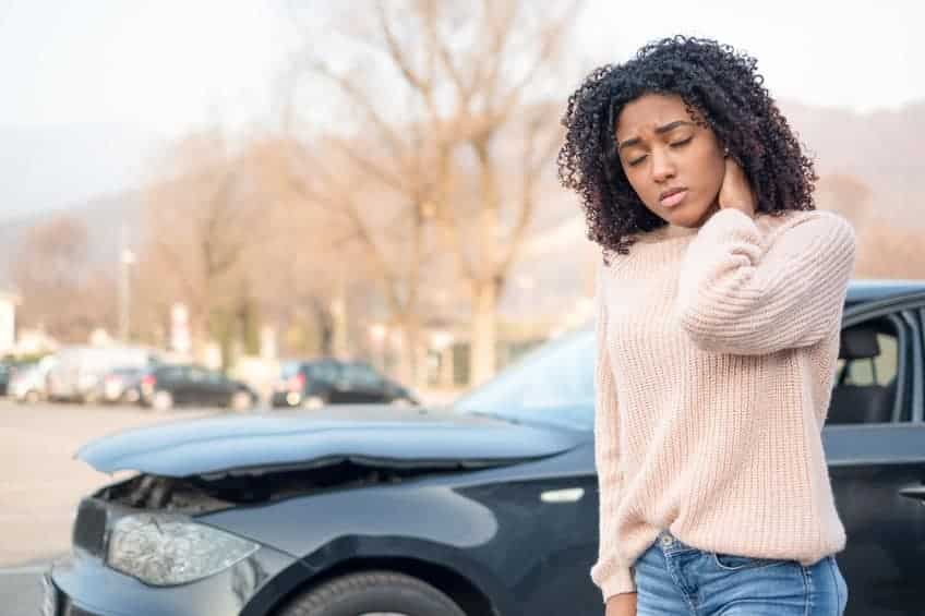 Injured woman feeling neck pain from whiplash after being in a car crash