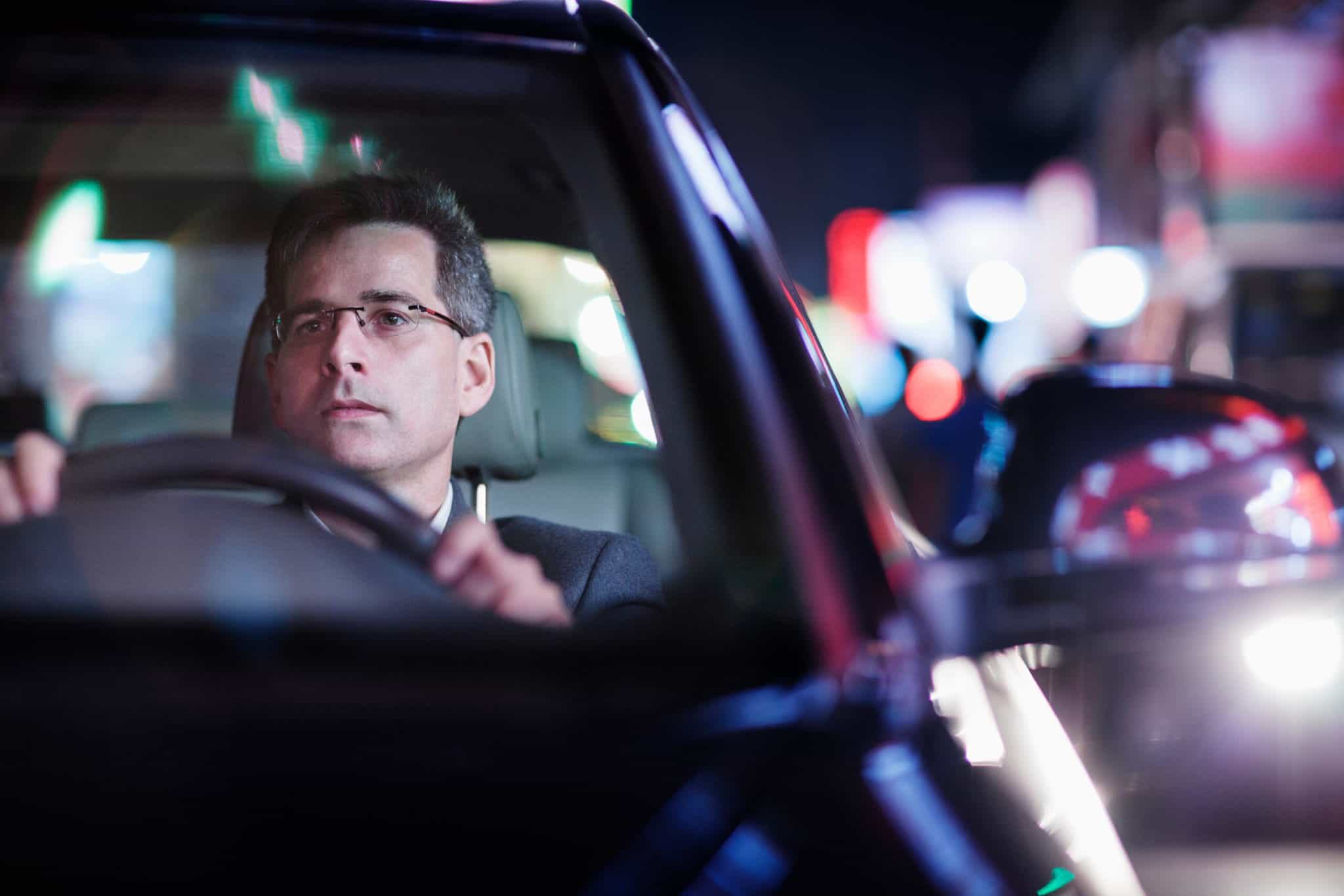 Businessman driving at night in the city at Halloween