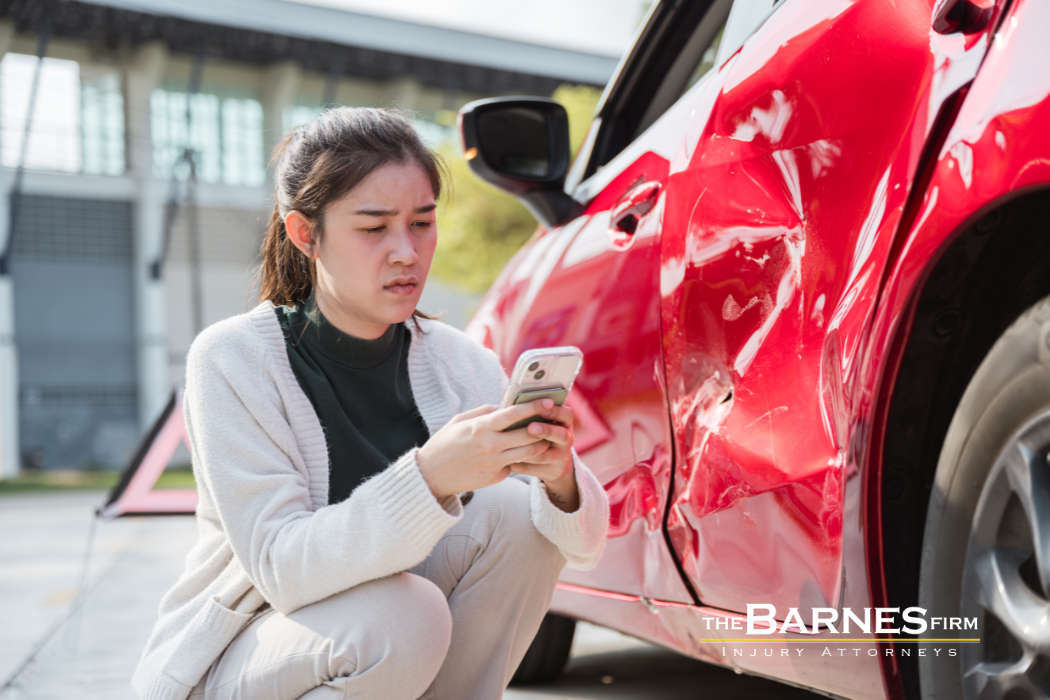 woman standing next to damaged vehicle after car accident